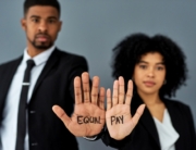 Image of POC with euqal pay written on palms facing outward